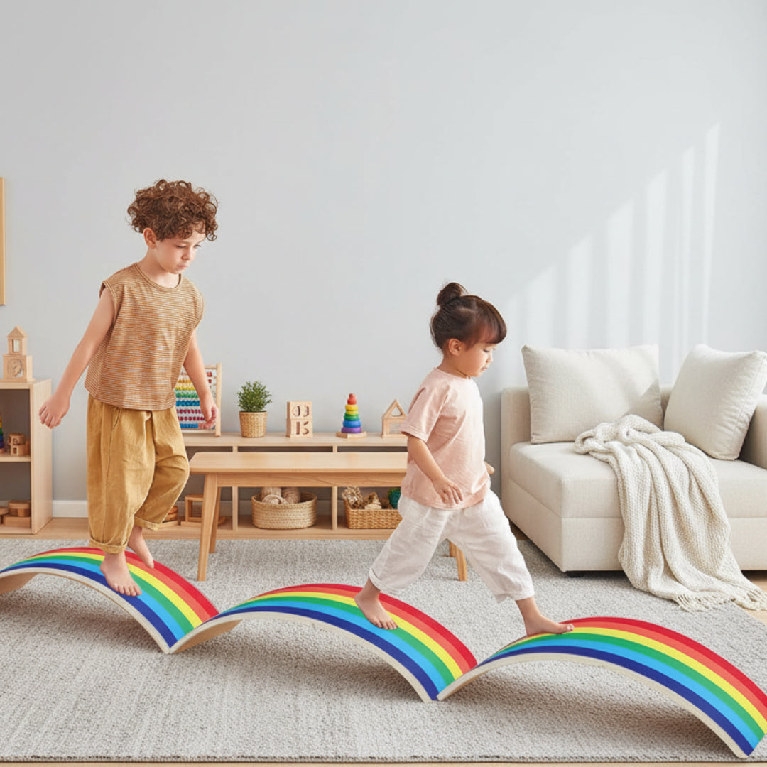 Two children playing on a rainbow-shaped balance board in a room with a teepee and toys.
